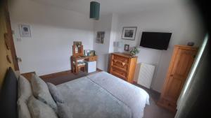 a bedroom with a bed and a dresser and a television at Lycia Rooms + in Inverness