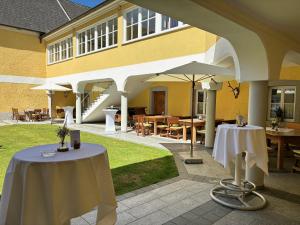 a patio with tables and umbrellas in front of a building at Gasthof Hehenberger in Wallsee