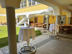 un patio con 2 mesas y una sombrilla en Gasthof Hehenberger en Wallsee