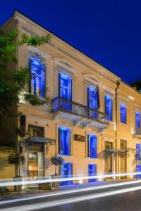 duży biały budynek z niebieskimi światłami w obiekcie Maison Grecque Hotel Extraordinaire w mieście Patras