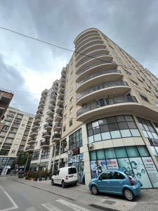 two cars parked in front of a large building at Apartment for holidays in Ferizaj