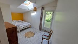 La bergerie d'Annie في بريفاس: غرفة نوم بها سرير ونافذة وكرسي