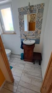 La bergerie d'Annie في بريفاس: حمام مع حوض و مرآة و مرحاض