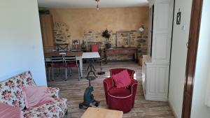 La bergerie d'Annie في بريفاس: غرفة معيشة مع كراسي حمراء وطاولة +13 صورة
