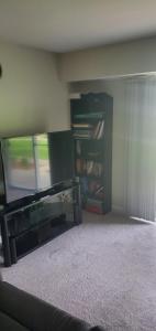 sala de estar con TV y estante de libros en Two Bedroom Apartment in Norwood en Norwood