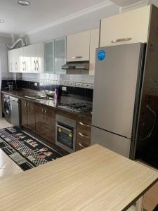 a kitchen with a refrigerator and a table in it at Achakar in Tangier