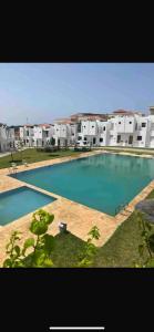 a large swimming pool in front of a building at Achakar in Tangier