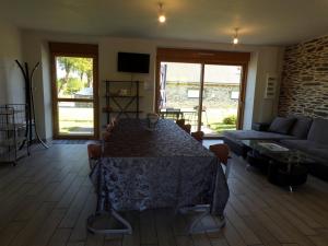 a living room with a table and a couch at LA ROSELIERE - Les Vergers de Guerledan in Guerlédan