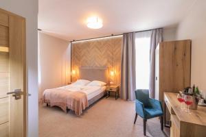 una camera d'albergo con letto e sedia blu di Pokoje Gościnne Cichosza a Szklarska Poręba