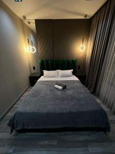 Un dormitorio con una cama grande con un libro. en Lux в ЖК K7-Family рядом аэропорт, en Atyraū