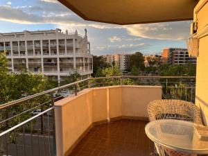 einen Balkon mit einem Tisch, einem Stuhl und einem Gebäude in der Unterkunft Apartamento en Salou in Salou