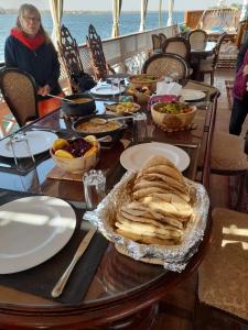 una mesa con un montón de comida. en Dahabiya Nile Cruise en Luxor
