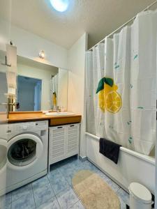 a bathroom with a washing machine and a shower curtain at Suite Victoria Near Disneyland in Chessy