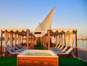 een terras van een boot met stoelen en een hot tub bij Dahabiya Nile Cruise in Luxor
