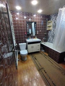 a bathroom with a toilet and a sink and a tub at GuestHouse ED&ER near airport in Geghanist