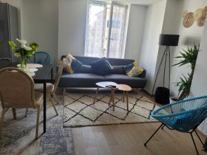 a living room with a blue couch and a table at Appartement privé à 15mn de Paris et proche Enghien les bains in Groslay