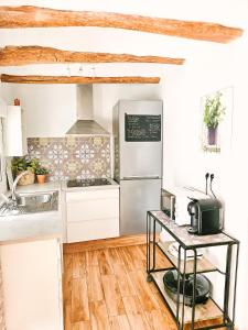 a kitchen with white cabinets and a refrigerator at Casa del Arquillo in Teruel