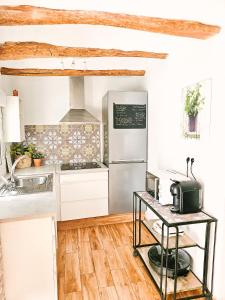 a kitchen with white cabinets and a refrigerator at Casa del Arquillo in Teruel +13 photos