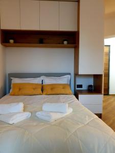 uma grande cama branca com duas almofadas em Central Nest Apartment em Brasov