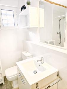 La salle de bains blanche est pourvue d'un lavabo et de toilettes. dans l'établissement Casa del Arquillo, à Teruel