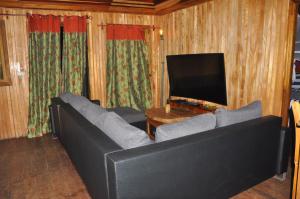 een woonkamer met een bank en een televisie bij Appartement Chalet type f3 in Kribi