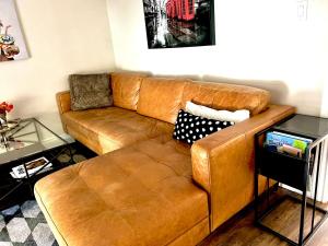 un sofá de cuero marrón en la sala de estar en Budapest - Heritage Tay Basin Water View, en Perth