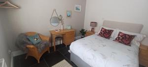1 dormitorio con cama, silla y escritorio en 5 Main Street en Llangwm