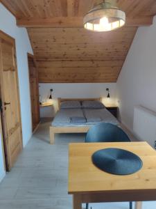 sypialnia z łóżkiem i drewnianym sufitem w obiekcie Jurajska Chata w mieście Bobolice