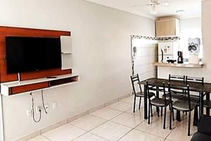 d'une salle à manger avec une table et une télévision à écran plat. dans l'établissement Ap Beira Mar Praia do Muta, à Coroa Vermelha