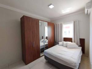 Coroa Vermelha的住宿－Ap Beira Mar Praia do Muta，一间卧室配有一张床和一面大镜子