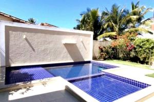 Coroa Vermelha的住宿－Ap Beira Mar Praia do Muta，一座位于房子一侧的蓝色瓷砖游泳池