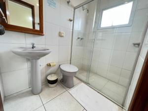 a bathroom with a shower and a sink and a toilet at Capão Praia Hotel in Capão da Canoa