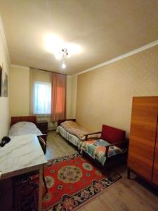 a room with two beds and a chair and a table at GuestHouse ED&ER near airport in Geghanist