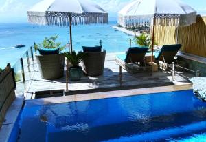 a swimming pool with a view of the ocean at Lembongan Harmony Villas in Nusa Lembongan