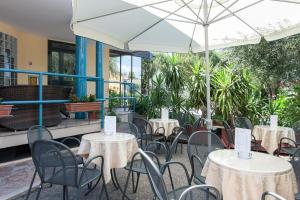 a group of tables and chairs with an umbrella at Hotel Los Angeles in Assisi