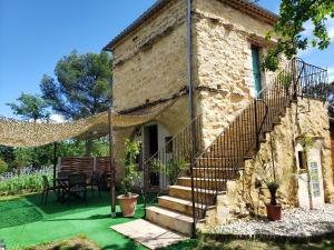 a stone house with stairs leading to a patio at Le Pigeonnier du Château in Saint-Victor-de-Malcap