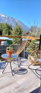 2 sedie sedute sopra un ponte di legno di Cabañas Seru a El Bolsón