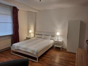 1 dormitorio con 1 cama y 2 lámparas en 2 mesas en City Apartments Magdeburg, en Magdeburgo