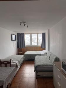a bedroom with three beds and a window at Sol del Sur Sierra Nevada in Sierra Nevada