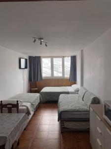 1 dormitorio con 3 camas y ventana en Sol del Sur Sierra Nevada, en Sierra Nevada