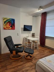 een woonkamer met een tafel en stoelen en een televisie bij City Apartments Magdeburg in Maagdenburg