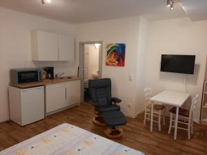 een keuken met een bureau, een stoel en een tafel bij City Apartments Magdeburg in Maagdenburg