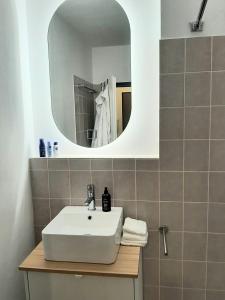 ein Badezimmer mit einem weißen Waschbecken und einem Spiegel in der Unterkunft Helle freundliche Wohnung am Stadtpark in Bobingen