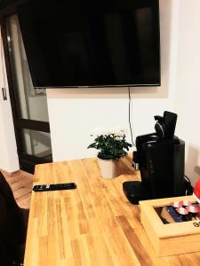 TV de pantalla plana en la parte superior de una mesa en Helle freundliche Wohnung am Stadtpark, en Bobingen