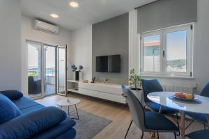 a living room with a blue couch and a table at Apartmani Jakić 2 in Hvar