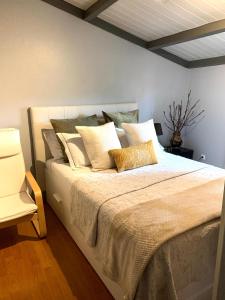 um quarto com uma cama grande com muitas almofadas em BlancoHouse. fozdodouro no Porto