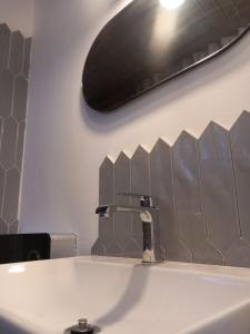 a bathroom sink with a black light above it at ZlatAir Twins 2 in Nova Varoš +19 photos