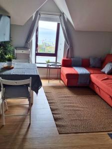 ein Wohnzimmer mit einem roten Sofa und einem Tisch in der Unterkunft Portrush by the Sea - 6 Golf Terrace in Portrush