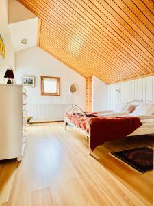 a bedroom with a bed in a room with a wooden ceiling at Large Architect designer home 800m from beach in Glumslöv