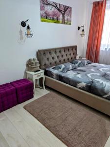 a bedroom with a large bed and a purple couch at White Studio in Câmpulung Moldovenesc